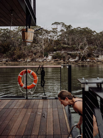Woman exiting the water after jumping off pontoon boat