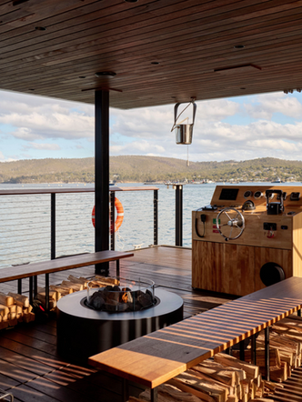 Outdoor deck of KUUMA floating sauna with tea station and water views.