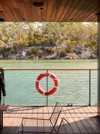 View from KUUMA floating sauna deck across calm Tasmanian water.