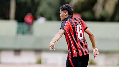 Jogador de futebol profissional em campo durante partida.