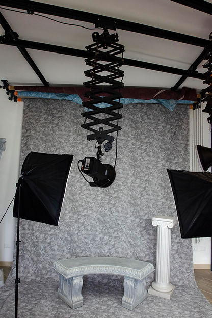 sala di posa con sfondo grigio e panchina stile classico presso un negozio di fotografo