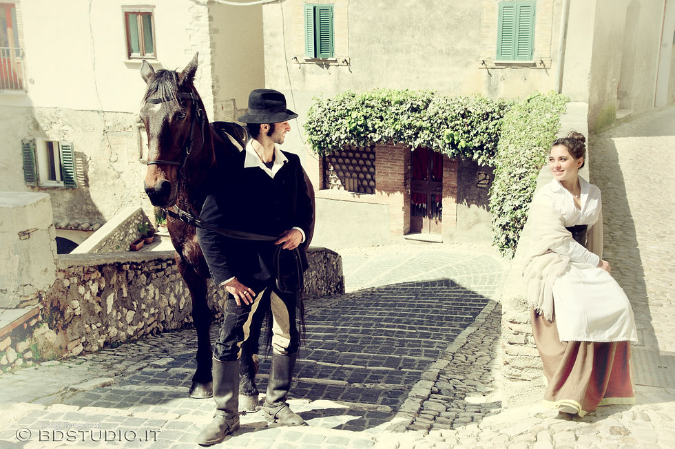 Foto a colori di un uomo e un cavallo in un paese medioevale.