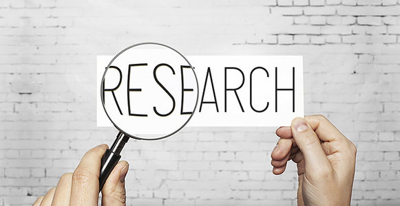 Photo of the word research under a magnifying glass