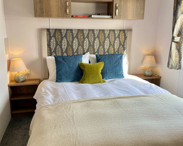 Bed with overhead storage. Bedside tables with lamps on top.