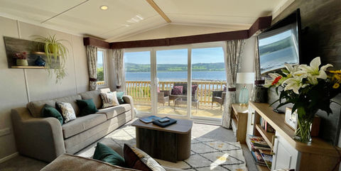 Modern living room with full length windows and decking facing the sea