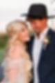 Golden hour wedding bride looking up at groom peach flowers