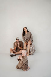 Image of mom and dad smiling at their baby clapping their hands.