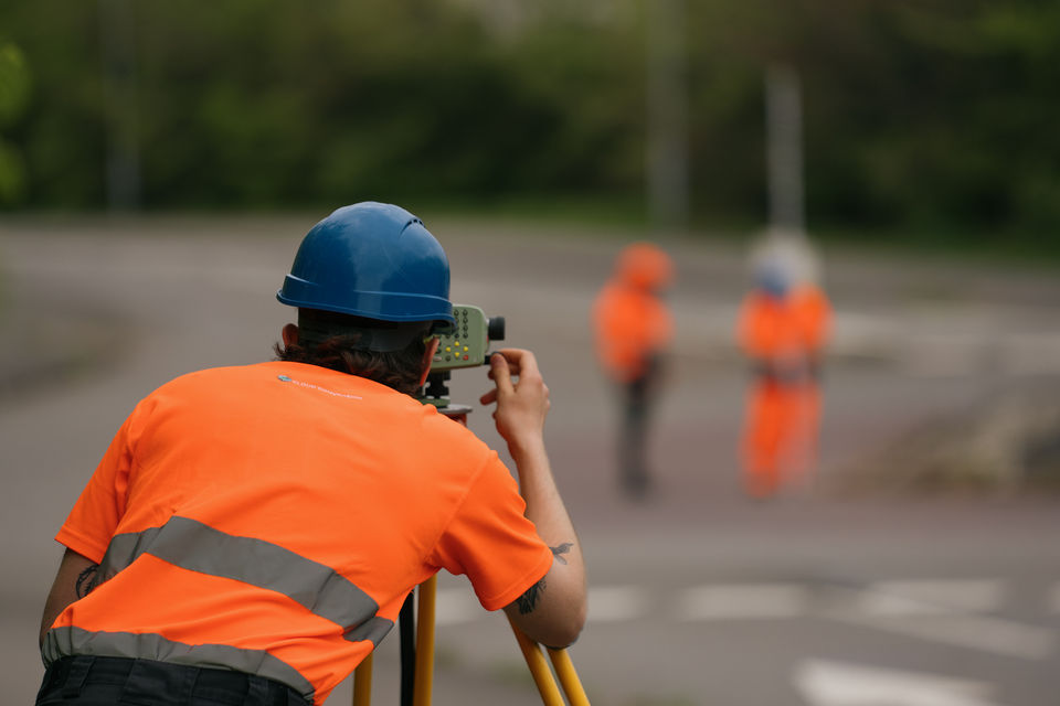 Leica TS16 robotic total station performing millimeter-accurate setting out for steel column foundations on high-rise project.