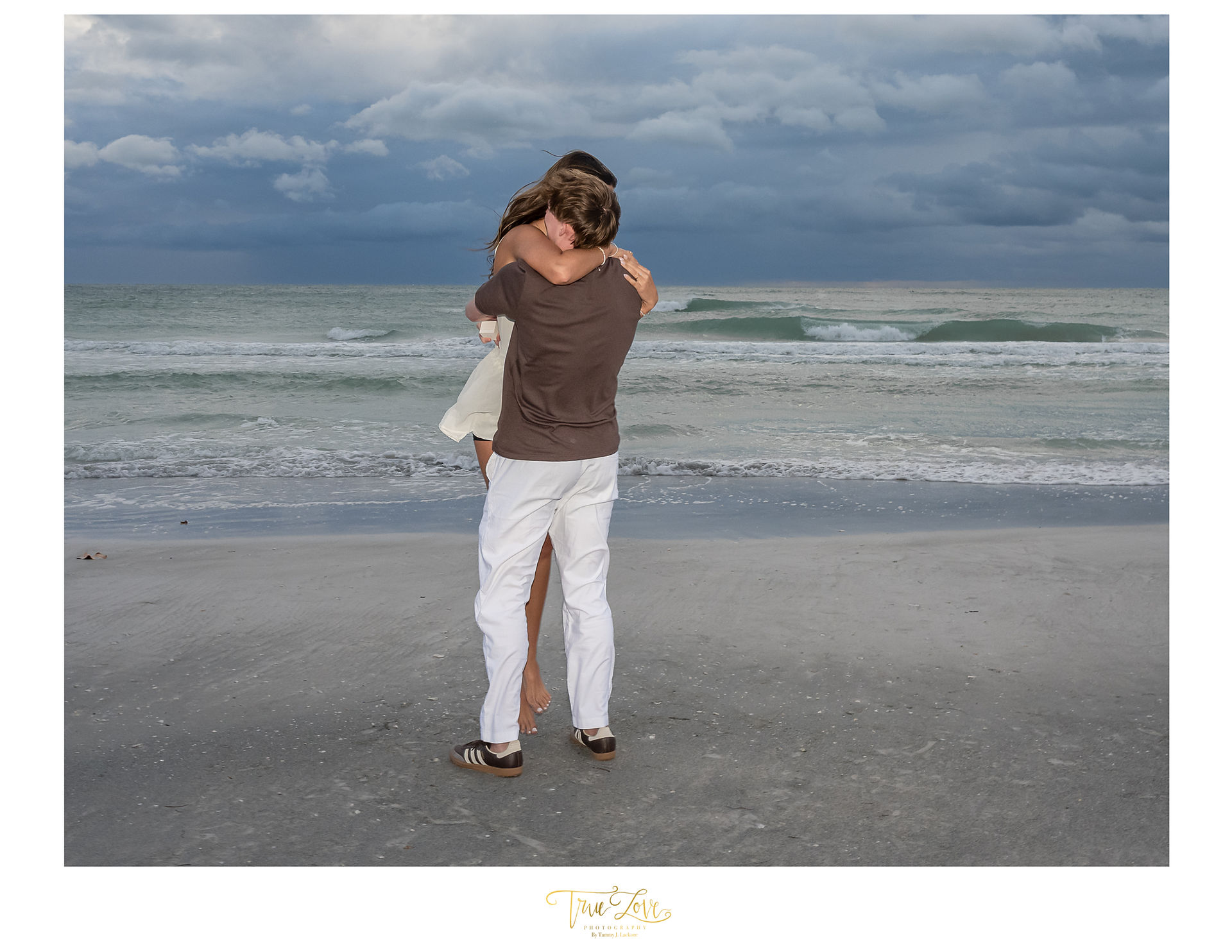 Man and Woman hugging on a windy beach