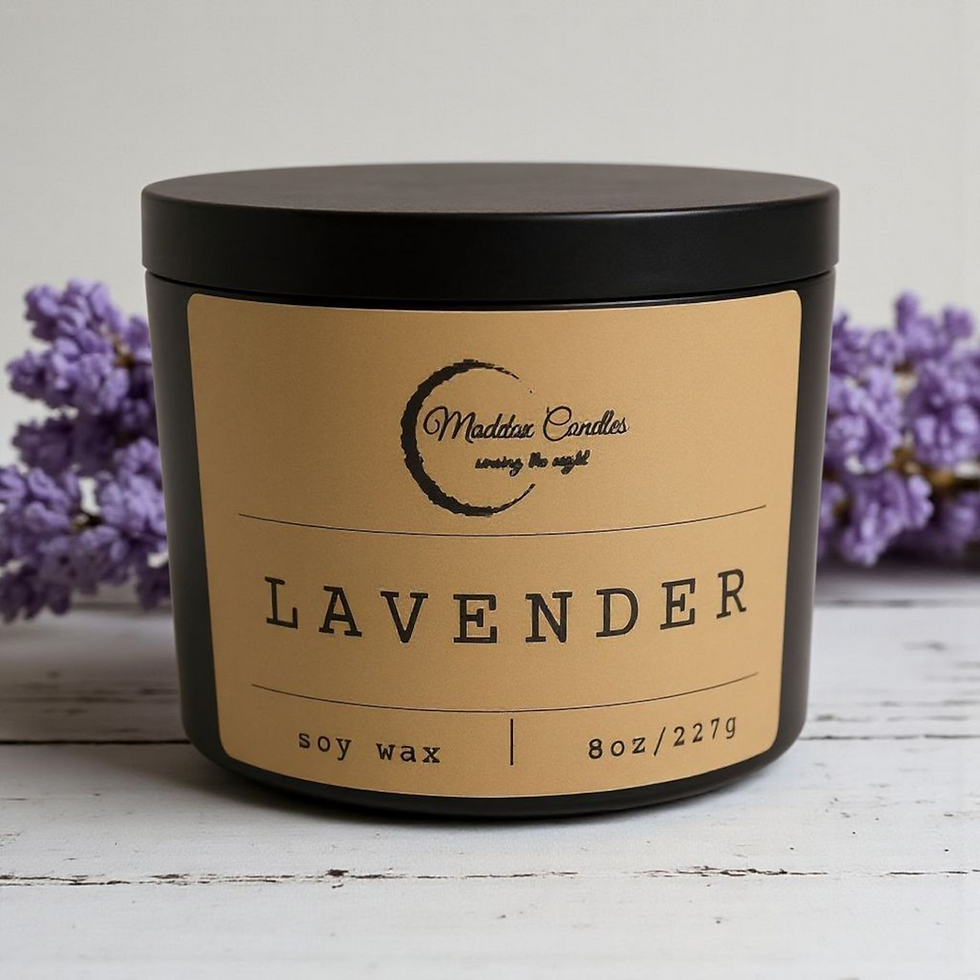Black candle reads Lavender Soy Wax 8oz Maddox Candles near purple flowers