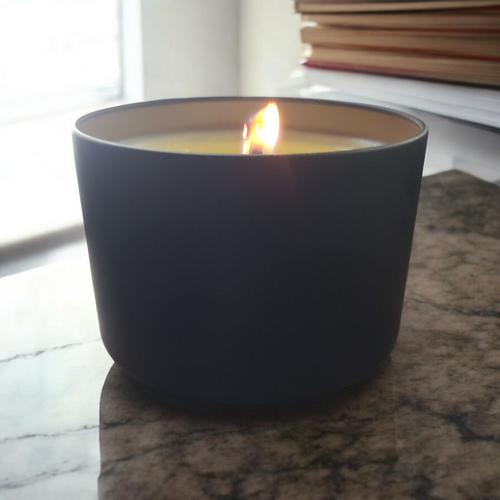 Thumbnail: Lit candle in a black container on a marble surface, books in background.