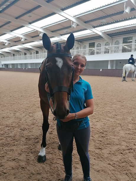 Sarah Holman posing with a horse that she was teaching with,
