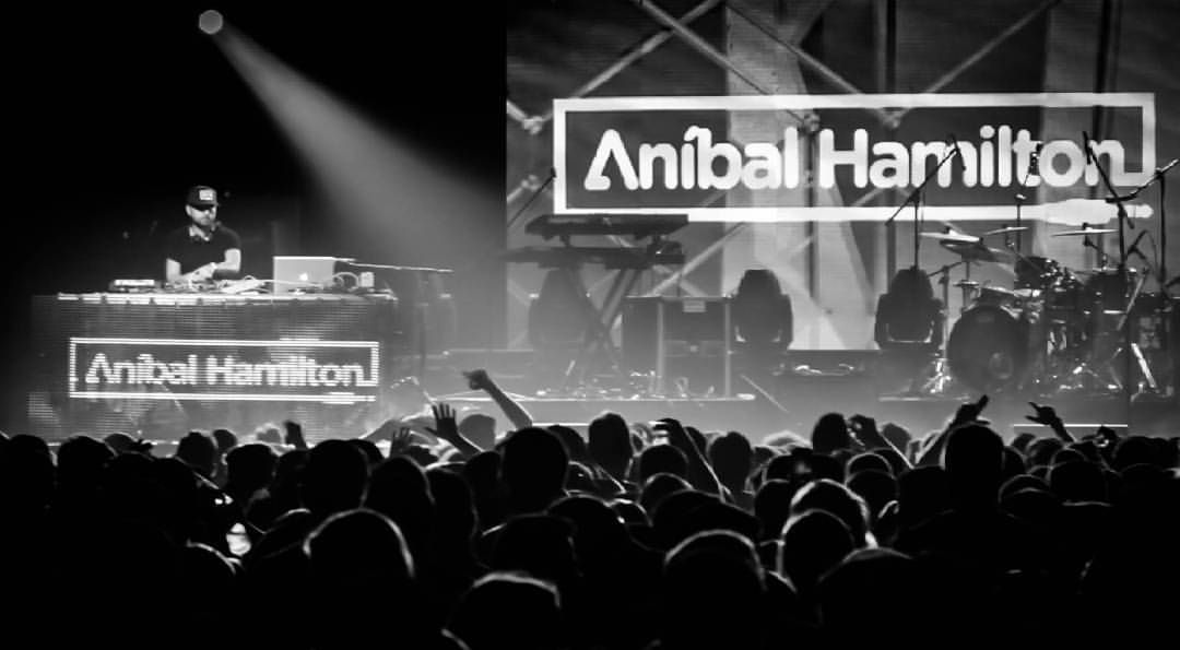 DJ Anibal Hamilton performing to a packed venue, photo in black and white