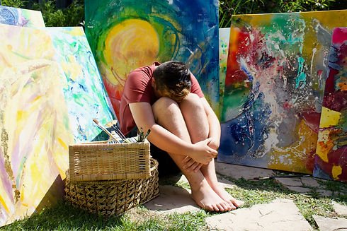 Artist Aiden lee hugging his knees into his chest