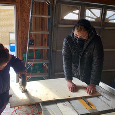 A peice of rectabgular plyboard being sanded and cut on a worktable.