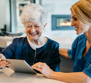 happy-senior-woman-using-tablet-computer-with-home-caregiver-CAVF25385.jpg