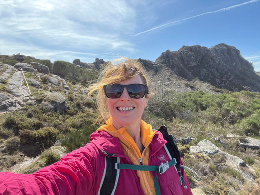 Fiona Marshall Yoga on a mountain hiking trail under blue skies.