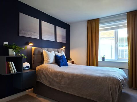 Trendy navy bedroom with ochre curtains