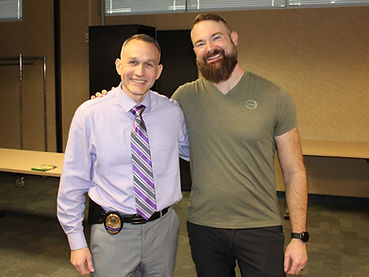 Plain clothes police chief and bearded man arm in arm