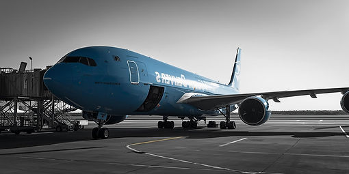generate image side view of a blue cargo delivery plane in the airport a light black colou
