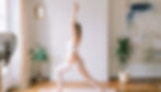 femme enceinte pratiquant la pose du yoga du guerrier dans des vêtements de yoga blancs
