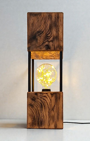 Tischleuchte „Lichtblick“ – Wohnlichkeit
Die stilvolle Tischleuchte „Lichtblick“ präsentiert sich in einem Alteiche Look mit modernen Akzenten. Diese einzigartige Leuchte hat ein modernes Design in Form eines in die Länge gezogenen Kubus und verbindet die natürliche Schönheit von Holz mit der Stabilität von Metall.
Die Tischlampe strahlt ein sanftes und warmes Licht aus, das eine gemütliche und entspannte Atmosphäre schafft. Ob als Nachttischlampe für dein Schlafzimmer, als gemütliches Licht in deinem Wohnzimmer oder als dezente Lichtquelle im Vorzimmer - überall ein echter Hingucker.
Schaltet man die Leuchte ein, so sieht aus, als ob die Lichtpunkte schweben. Ein Kunstwerk, das Ihre Wohnumgebung erhellt und aufwertet.