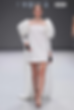 Model walks runway in a white dress with puffed sleeves and black gloves. Gray background with "SOPHIE ET VOILÀ" text. Elegant mood.