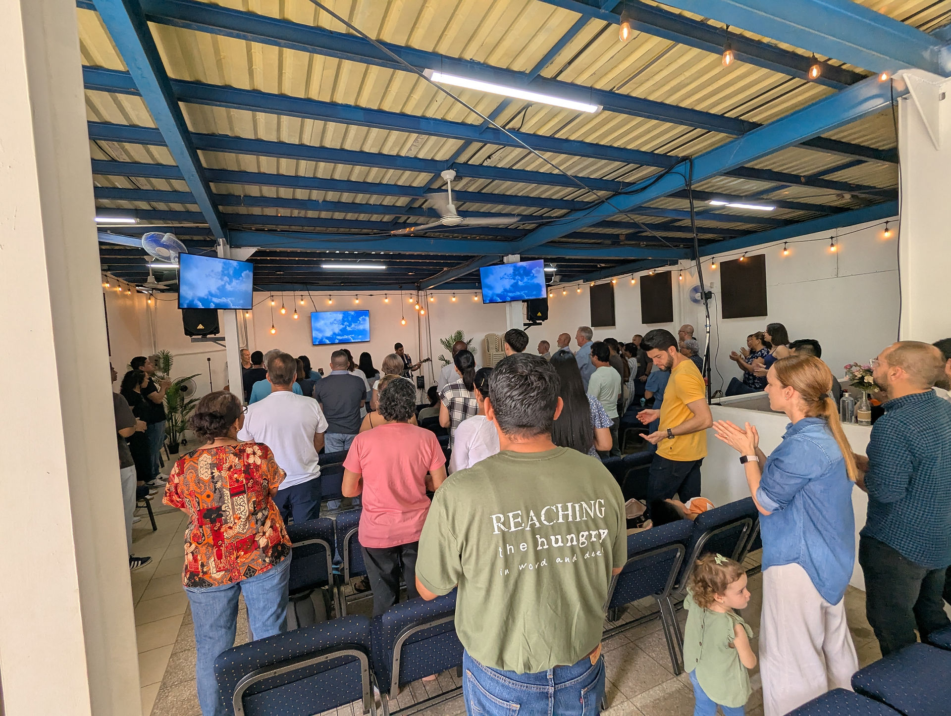 Audience singing along during a worship session inside the church.