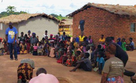 Malawian villagers listening to the RTH Malawi Team.