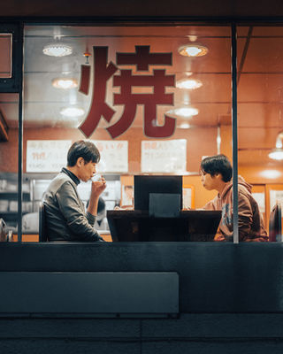 A close-up shot through the window of a Tokyo restaurant, where two men sit and enjoy their meal, with the word "焼" (grill) boldly displayed on the glass. The warm indoor lighting creates a welcoming atmosphere. NFT Photography by Tokyo Photographer Deniz Demir. Tokyo, Japan.





