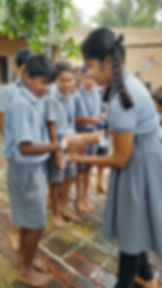 Girl tying Rakhi on a boy's wrist at school gallery