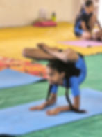 Young girl performing an advanced yoga pose on a mat.