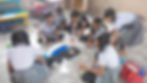 Students in uniforms creating floor art in a classroom