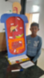Student presenting a handmade human digestive system model