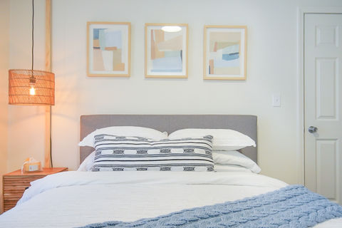 Big comfortable bed, with white comfortable cover and a subtle glow of light.