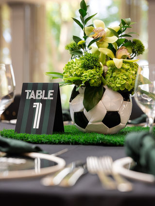 Soccer-ball floral centrepiece with a custom Table 7 sign