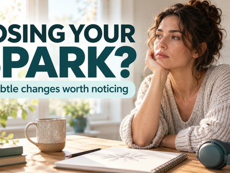 Woman sitting at a kitchen table with a notebook, mug, and headphones, looking pensive beside the text “Losing your spark? 7 subtle changes worth noticing.”