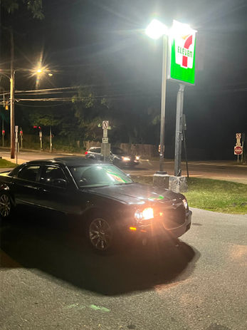 Black car parked in front of 7-Eleven at night Humbl.Online
