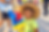 Child wearing colorful face paint and proudly holding a bright balloon creation at a Doodle & Pop event.