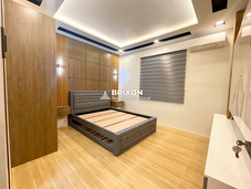 Bedroom with ambient lighting, gray bed frame, and wide window shades for privacy.