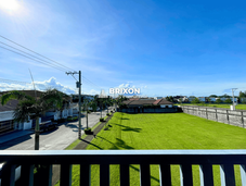 Spacious front yard with green grass and fence view