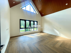 Bedroom with vaulted wooden ceiling and wide glass windows.