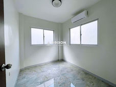 Well-lit room with white walls and polished flooring, ideal for a guest or study room.