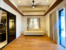 Ground floor bedroom with wooden flooring and large windows