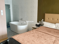 Premium room with upholstered headboard and standalone bathtub beside the bed.