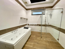 Master bathroom with bathtub and wood-accent flooring