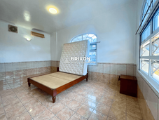Bedroom with large windows, tiled flooring, and natural daylight.