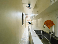 Dirty kitchen with stainless sink and tiled backsplash.
