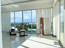 Spacious indoor lounge with white marble flooring and direct access to balcony