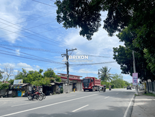 Busy main road with vehicles, shops, and pedestrians in Capas, Tarlac